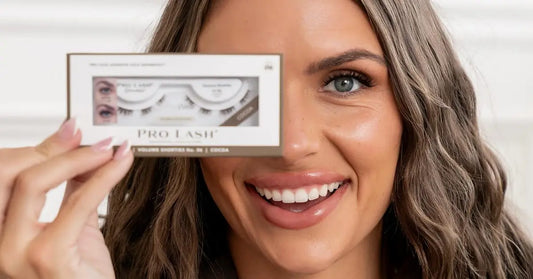 DIY eyelash application demonstrated by a smiling woman holding a Pro Lash box over one eye