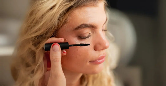 Eyelash Extensions being enhanced with mascara on woman’s natural lashes.