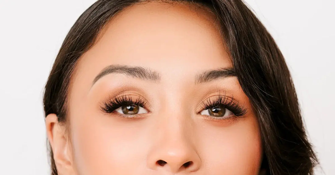 Mega volume lashes applied on woman with warm-toned eyeshadow and perfectly groomed brows.