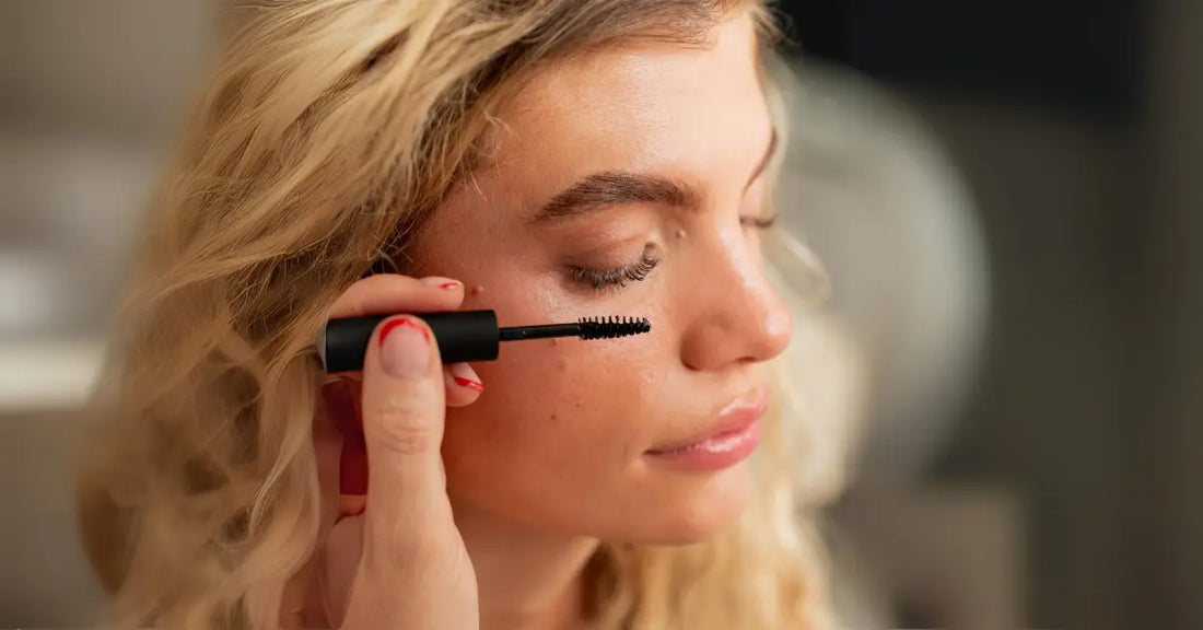 Eyelash Extensions being enhanced with mascara on woman’s natural lashes.