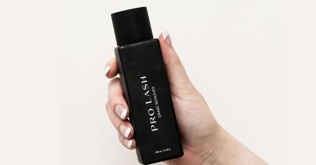 At-home lash extensions remover held in hand with clean, polished nails against a neutral background.