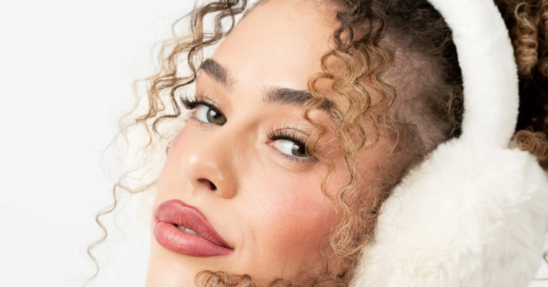 Better lash retention demonstrated with full, styled lash extensions on model wearing earmuffs, showcasing long-lasting volume and curl.