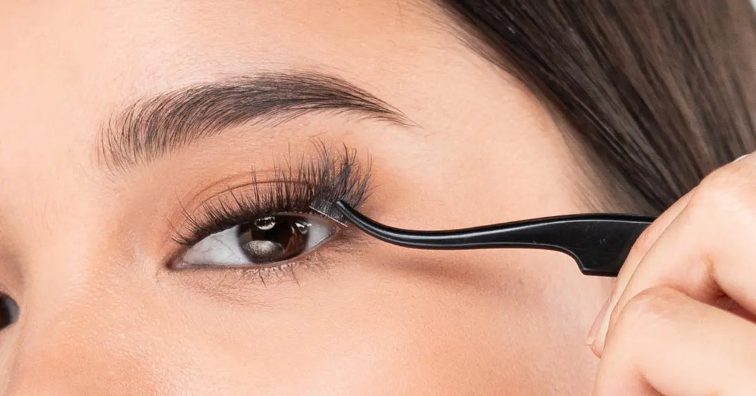 Hybrid eyelash styles being applied with tweezers, blending classic and volume lashes for a soft, full look