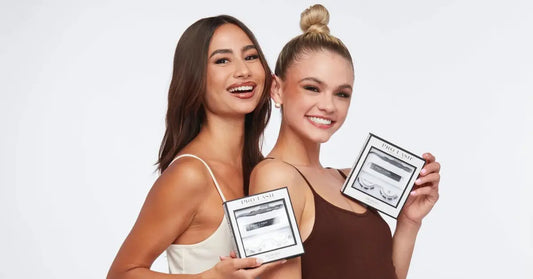 Wispy lash extensions featured in Pro Lash kits held by two smiling women in tank tops.