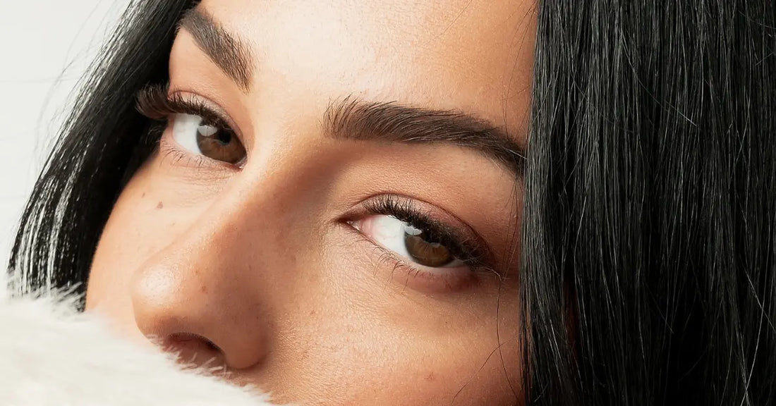 Natural eyelash extensions enhancing a woman’s brown eyes with soft, subtle volume and a natural finish