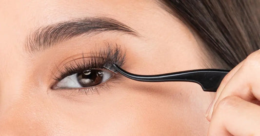Natural volume lashes being applied with tweezers for a soft, full look close to the lash line