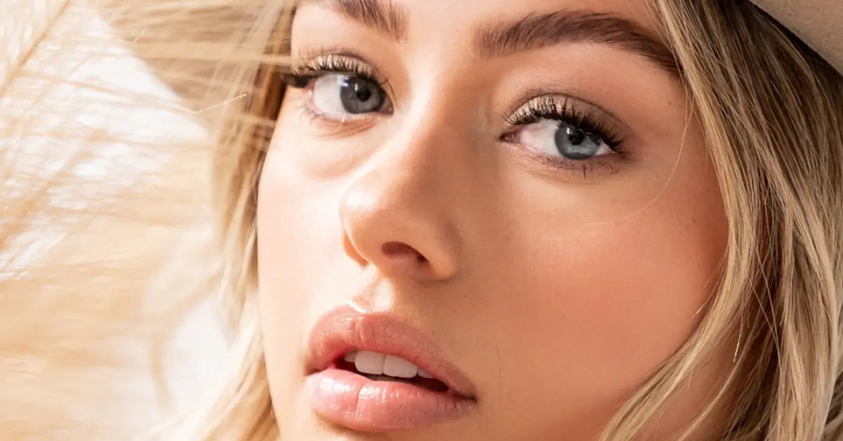 Best lash extensions shown on a close-up of a blonde woman with long, defined lashes and blue eyes.