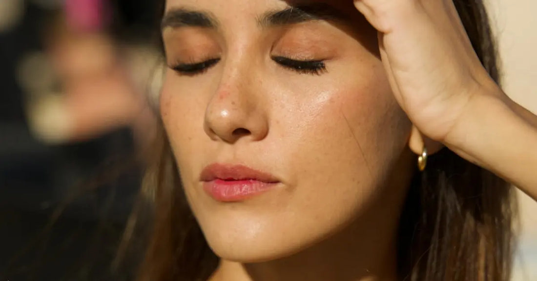 Sweat-proof lash extensions worn by a woman outdoors, eyes closed in sunlight with no smudging or lifting.