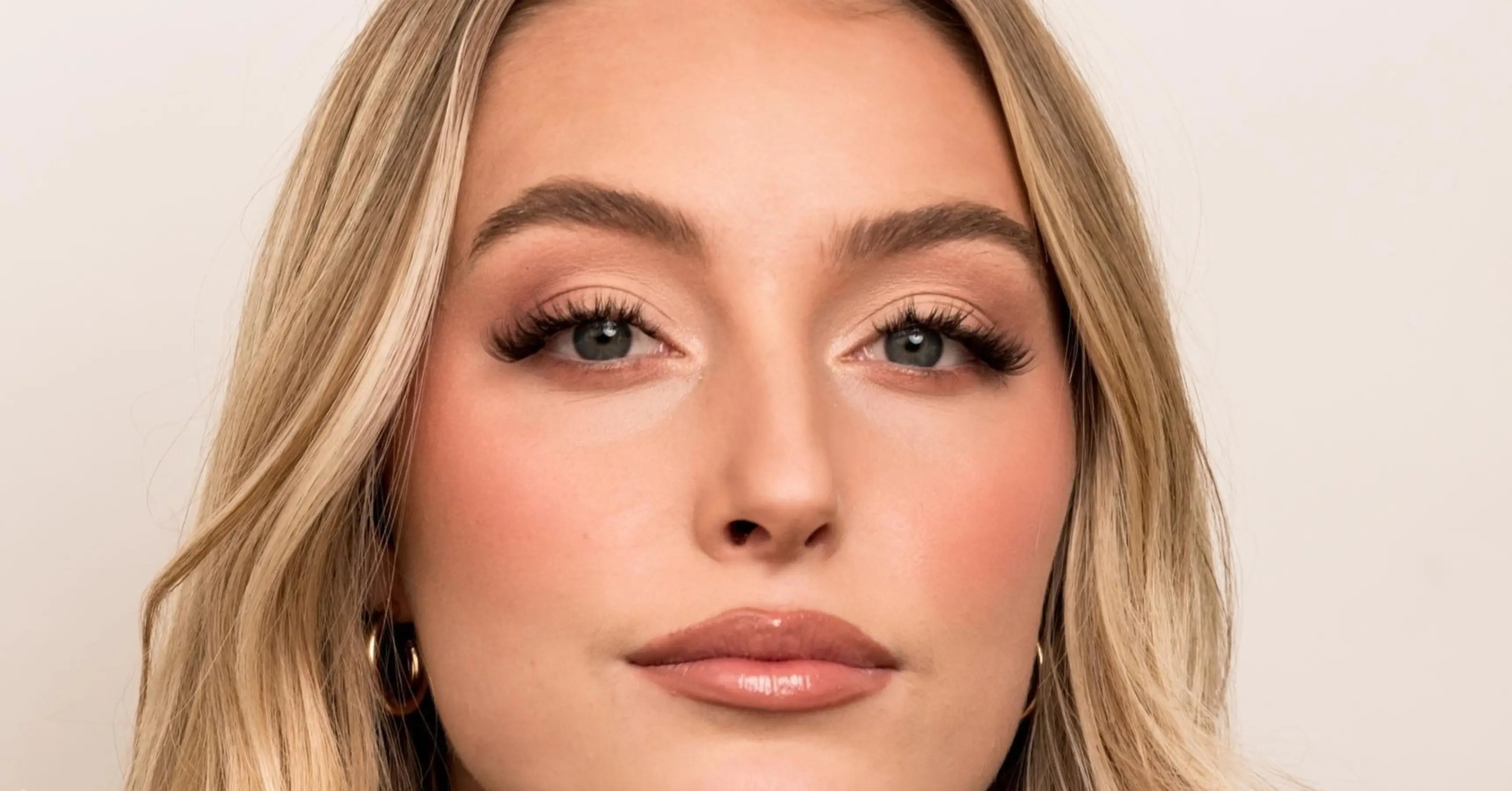 Top lash techniques shown in close-up portrait of model with softly curled, professionally styled eyelash extensions.