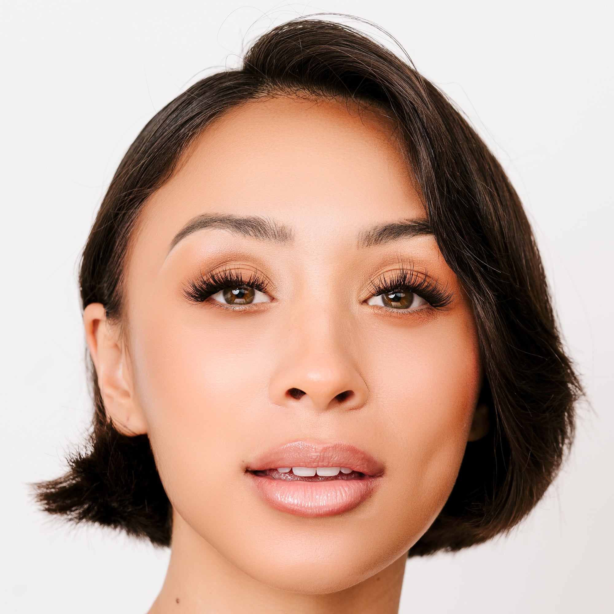 Eyelash extensions mega style shown on woman with full, voluminous lashes and flawless makeup.