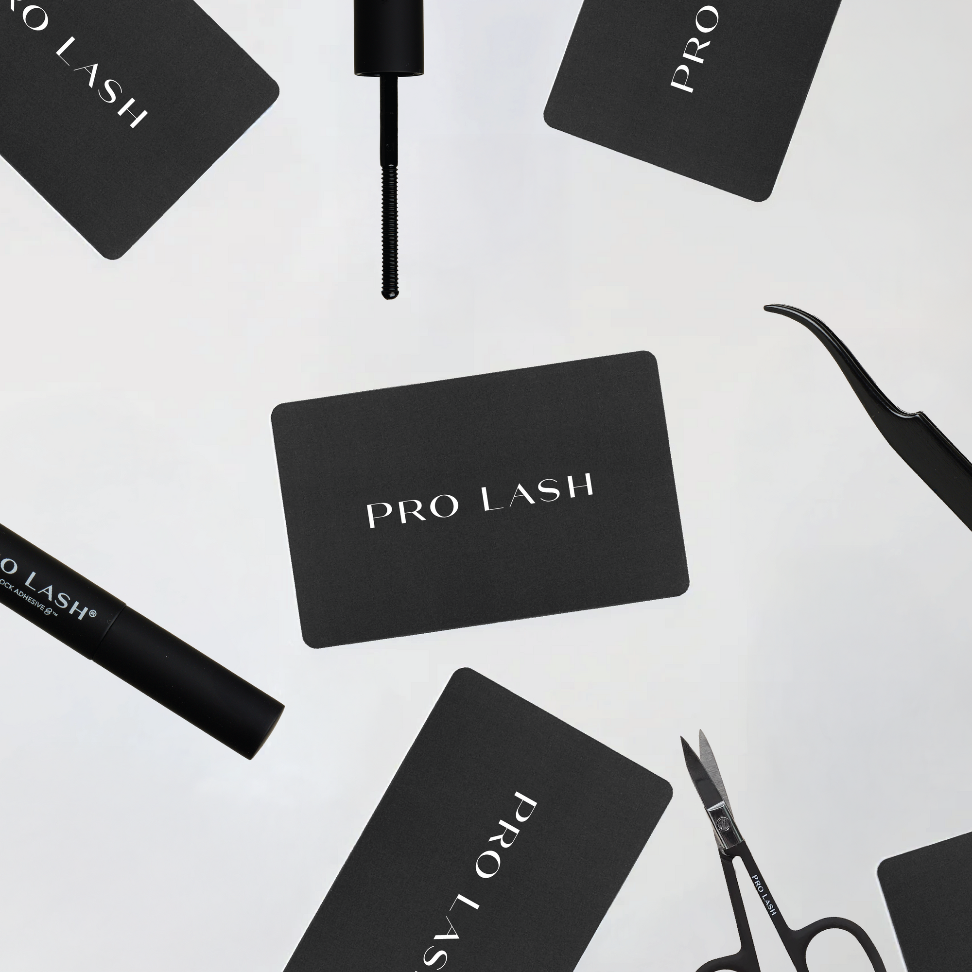 Black 'PRO LASH' cards and eyelash tools on a white background